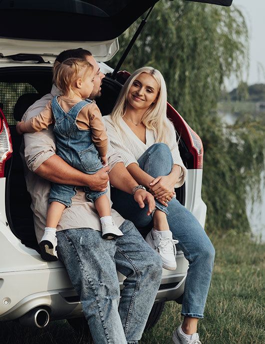 Young family enjoying a new car.